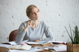 Woman at the desk, trying to figure out why her furnace is making noises.