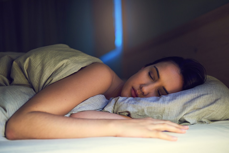 woman resting comfortably and gaining 3 health benefits for using her ac while sleeping