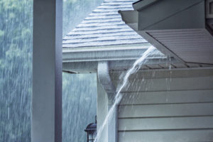 Rain pouring on house representing how you can protect your AC from storms