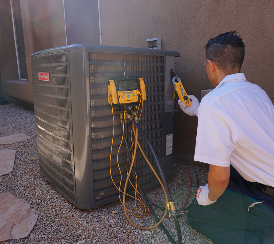 Scottsdale Air technician diagnosing an outdoor AC unit with gauges and a multimeter